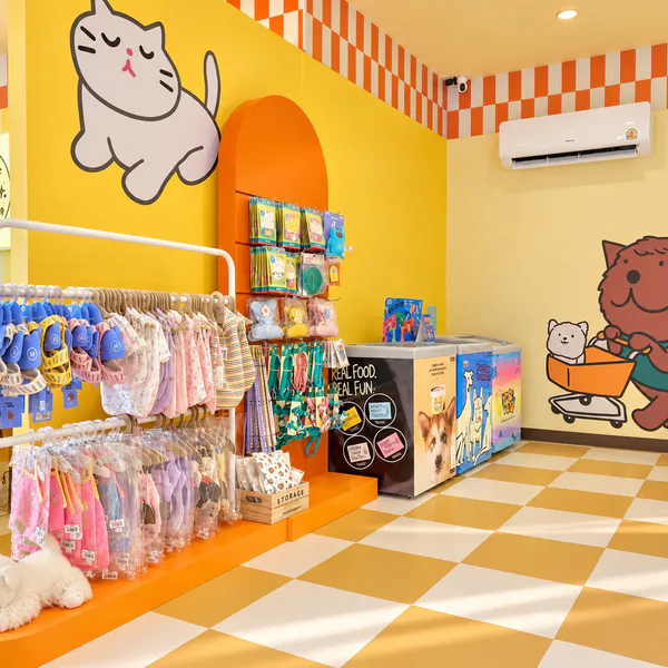 The pet shop at The Park: a yellow wall with a cat mural, pet clothes and accessories